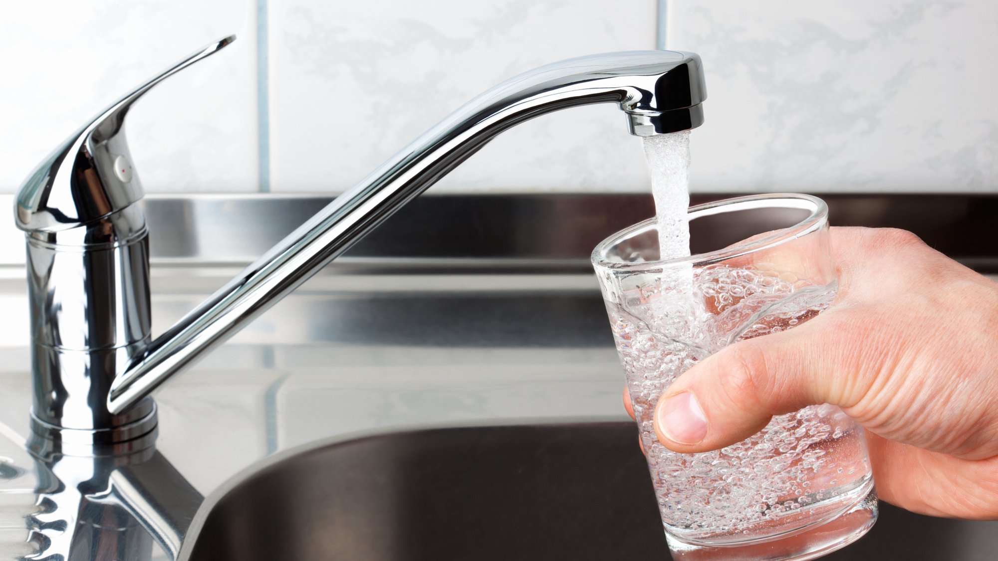 Filling a glass with water from kitchen tap